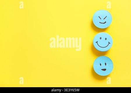 Sticky notes with smiley faces on yellow background Stock Photo