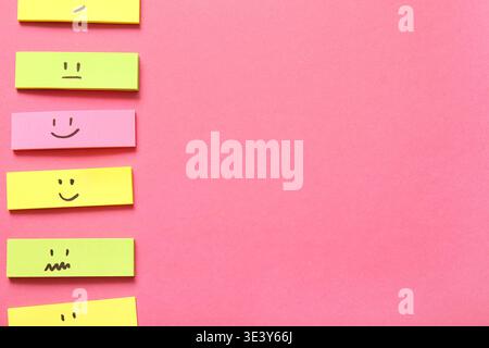 Sticky notes with drawings of different emotion faces on pink background Stock Photo