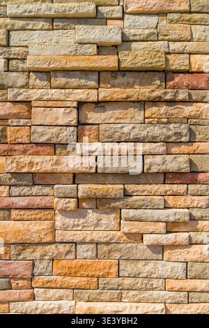 Close-up of a vertical column covered with natural stone blocks in various shades. Stock Photo