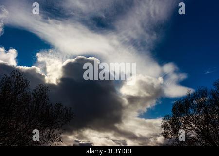 Dramatic sky with powerful, contrasting clouds. Deep blue peeking through, creating a majestic and moody atmosphere Stock Photo