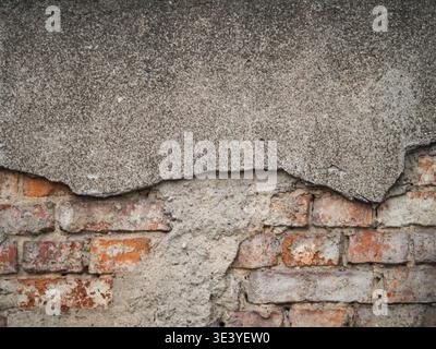 Weathered concrete cracks over aged red bricks. Textured surfaces show decay and time's passage. Rust stains and crumbling mortar tell of neglect. Ide Stock Photo