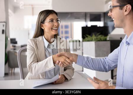 Business partners shaking hands after successful deal in office Stock Photo