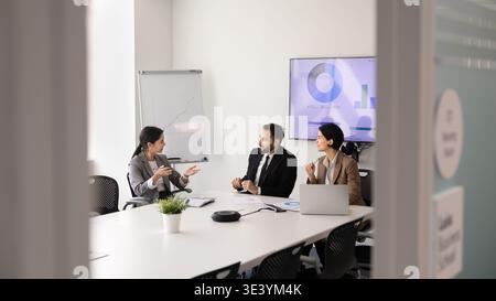 Diverse business executives discussing financial strategy in conference room Stock Photo