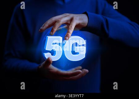 Holding a glowing 5G symbol in hands during a tech demonstration Stock Photo