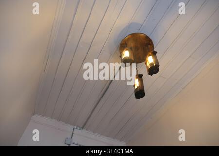 Ceiling light fixture with three lamps in a room Stock Photo