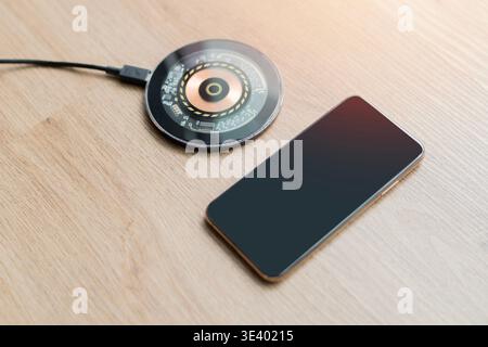 Modern wireless charger electrical circuit board style on a wooden background, accompanied by a USB cable and smart device icon, showcasing futuristic Stock Photo