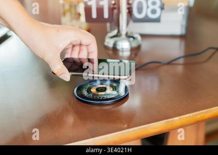 Woman with Phone charge. Mobile cell phone charge battery from wireless smart charger. Modern technology, portable fast charger. Stock Photo