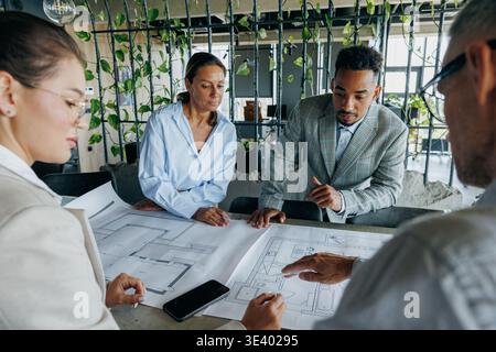 Group Of Architects And Engineers Collaboratively Assess Detailed Plans For Urban Construction Project Stock Photo