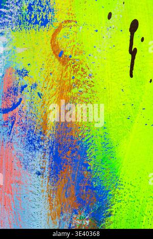 Energetic abstract canvas featuring multicolored acrylic splatters and streaks in green, yellow, blue, pink, and purple for creative backgrounds. Stock Photo