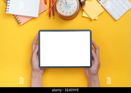 Tablet and school supplies on yellow background Stock Photo