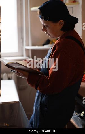 Female repairman writing notes while working in workshop. DIY concept. copy space Stock Photo