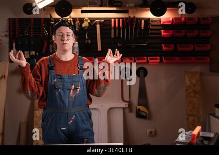 Artisan, handyman, carpenter or Industrial worker with equipment for repairs meditation on workspace in workshop. DIY repair and maintenance for job. Stock Photo