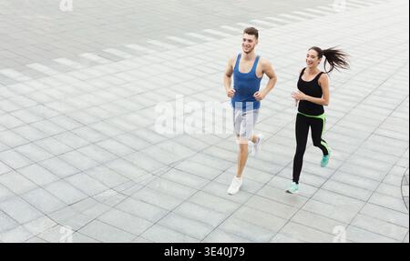 Two Individuals Are Jogging on a City Street Stock Photo