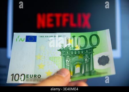 Belgrade, Serbia - February 24, 2026: 100 Euro bill in hand. Paying for Netflix. Netflix is a leading global subscription-based streaming service allo Stock Photo