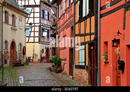 Bright and colorful traditional half-timbered houses in Alsace, France, during Easter, featuring cobblestone streets and spring blooms under soft daylight Stock Photo