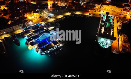Aerial view of the illuminated waterfront and harbor at night ...