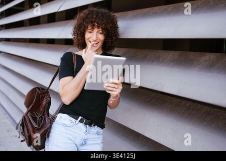 Outdoor woman with electronic device. Casual woman checking messages in daylight outside Stock Photo