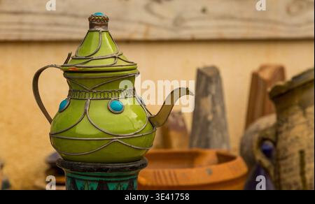 A green ceramic teapot on display to customers outside of a shop in the Atlas Mountains near Taghazout in Morocco Stock Photo