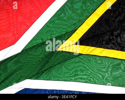 Close-up background of the South African national flag featuring vibrant fabric textures, mesh detail, and the iconic rainbow nation colours in an abs Stock Photo