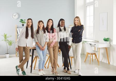 Diverse group of five women in professional workplace environment, girls team portrait unity Stock Photo