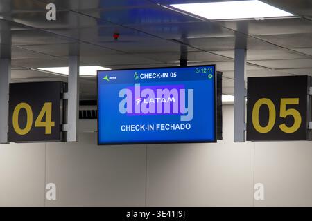 Closed airport check-in counter with a LATAM Airlines electronic display. Stock Photo