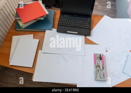 Workspace laptop, technical drawings, compasses, office supplies, top view of architect's desk, geometric sketches. Drawing training. Homework on the table. Sheets of paper notebook Stock Photo