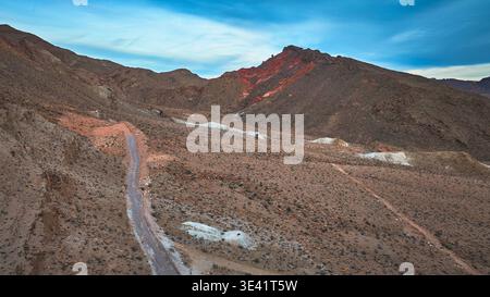 Aerial view of a winding mountain road through the dense autumn forest ...