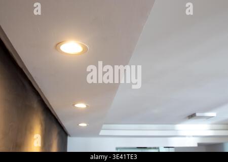 Detail of recessed ceiling lighting with LED spotlights lit in a residential interior. Stock Photo