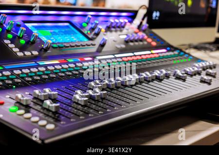 Recording studio features large mixing console with numerous controls, buttons during recording studio sound Stock Photo