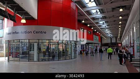 Interior of Warrington Bus Interchange, showing the Travel Information Centre, passenger concourse, stands and commuter footfall. Stock Photo