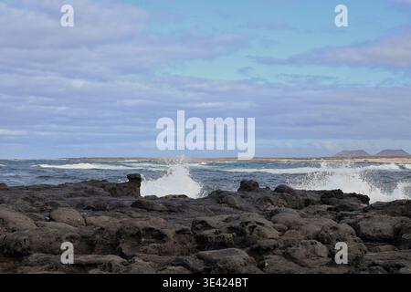 High waves from the Atlantic Ocean break on the rocky beach of Fuerteventura Stock Photo