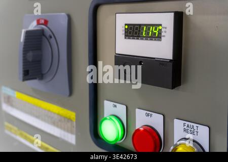 Digital display shows 88.88.114. Green light indicates system is active. Red button for emergency shutdown. Yellow button for fault reset. Panel has s Stock Photo