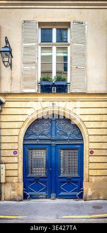 Paris, France, March 25th, 2025, view of a wooden decorated blue entrance door at 48 Jacob Street in the 6th district Stock Photo