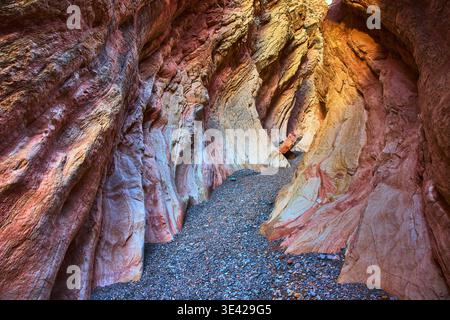 Colorful Slot Canyon Rock Walls and Gravel Path in Natural Sunlight Stock Photo