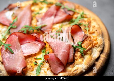 Prosciutto Pizza or Jamon Pizza extremely detailed and close up. Classic italian whole prosciutto and gorgonzola cheese pizza with arugula. Stock Photo