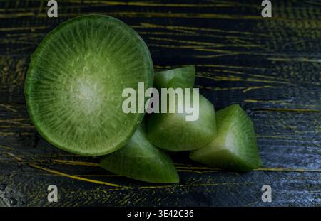 Fresh green radish and bunch of red radishes on a dark wooden background Stock Photo