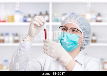 Focused scientist analyzing blood sample in test tube, laboratory research and clinical diagnostics concept in modern healthcare setting Stock Photo