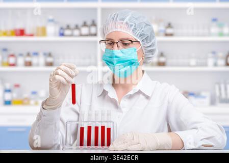 Laboratory technician arranging blood samples in test tube rack, clinical diagnostics and medical testing workflow in sterile environment Stock Photo