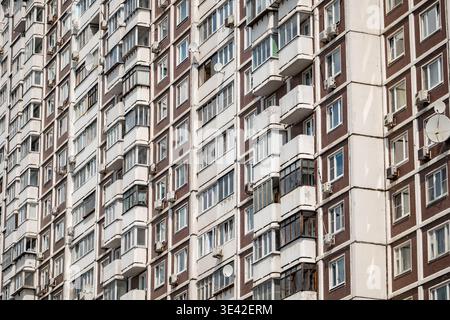 Soviet apartment building facade featuring repeating windows and balconies pattern Stock Photo