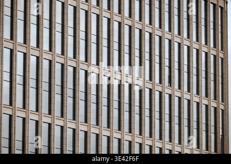 Modern building facade presenting repeating vertical glass windows and structure Stock Photo