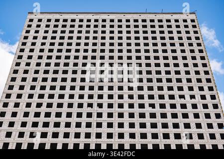 Concrete residential building showing many empty rectangular windows and repeating pattern Stock Photo