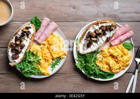 Healthy balanced breakfast plates. Scrambled eggs, greens, ham, sandwich with cream cheese and fried mushrooms.  Breakfast for two, breakfast together Stock Photo