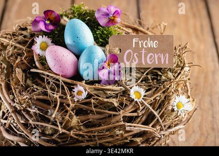 Easter basket with colorful Easter eggs, spring flowers and German Text  for Happy Easter Stock Photo