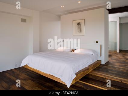 Minimalist Aspen bedroom with floating wooden platform bed Stock Photo