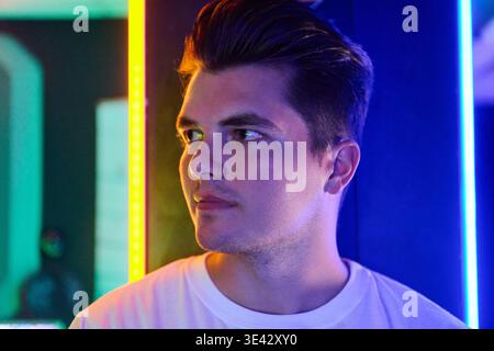 Young Man Portrait in Neon Light Looking Away Thoughtful Urban Night Profile Stock Photo