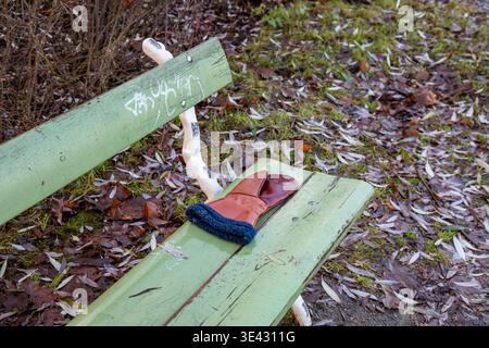Lost leather mitten on a park bench in Hesperia Park, Helsinki, Finland Stock Photo