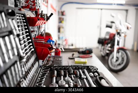 Mechanic Instruments And Tools On A Workbench With A Motorcycle In A Garage Stock Photo