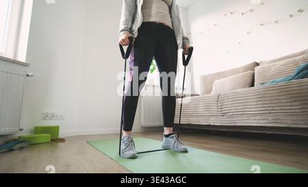 Girl Doing Fitness Exercises For Arms And Shoulders With Rubber Resistance Band Stock Photo