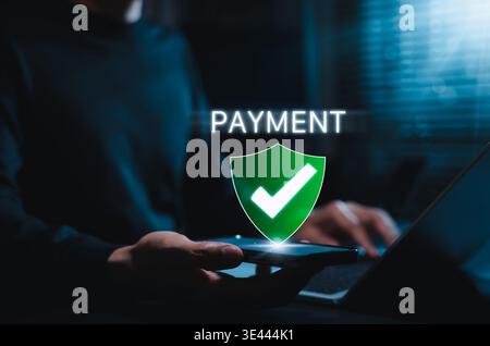 Secure Payment Verification and Digital Transaction Safety Concept. Person using smartphone with payment text and shield check icon, fintech security, Stock Photo