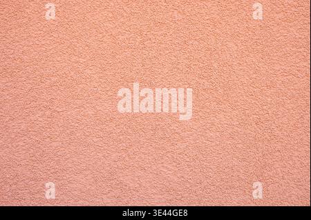 Rough salmon pink stucco wall texture background. Abstract grainy plaster surface Stock Photo